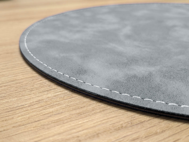 Close-up of the white stitched edge of the 1.3 mm round mouse pad