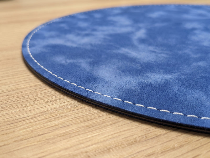 Close-up of the white stitched edge of the 1.3 mm round mouse pad